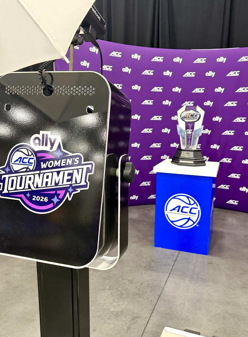 Guest posing with the ACC Women's trophy at the Ally branded photo experience