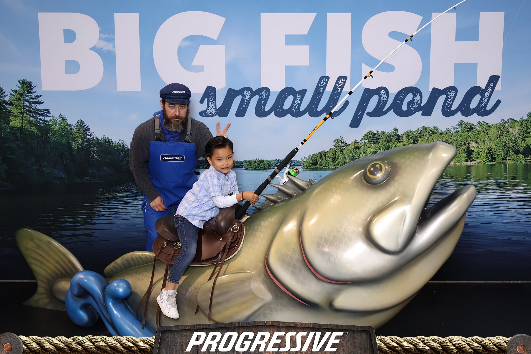 Child riding a saddled giant bass sculpture at Progressive's Big Fish Small Pond activation