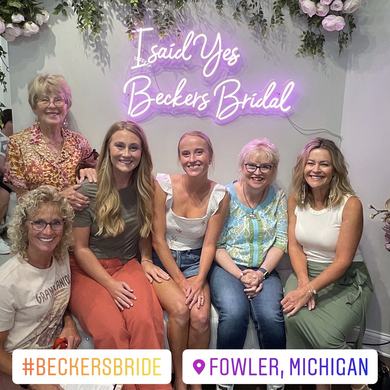 Bridal party photographed under an I Said Yes neon sign at Beckers Bridal