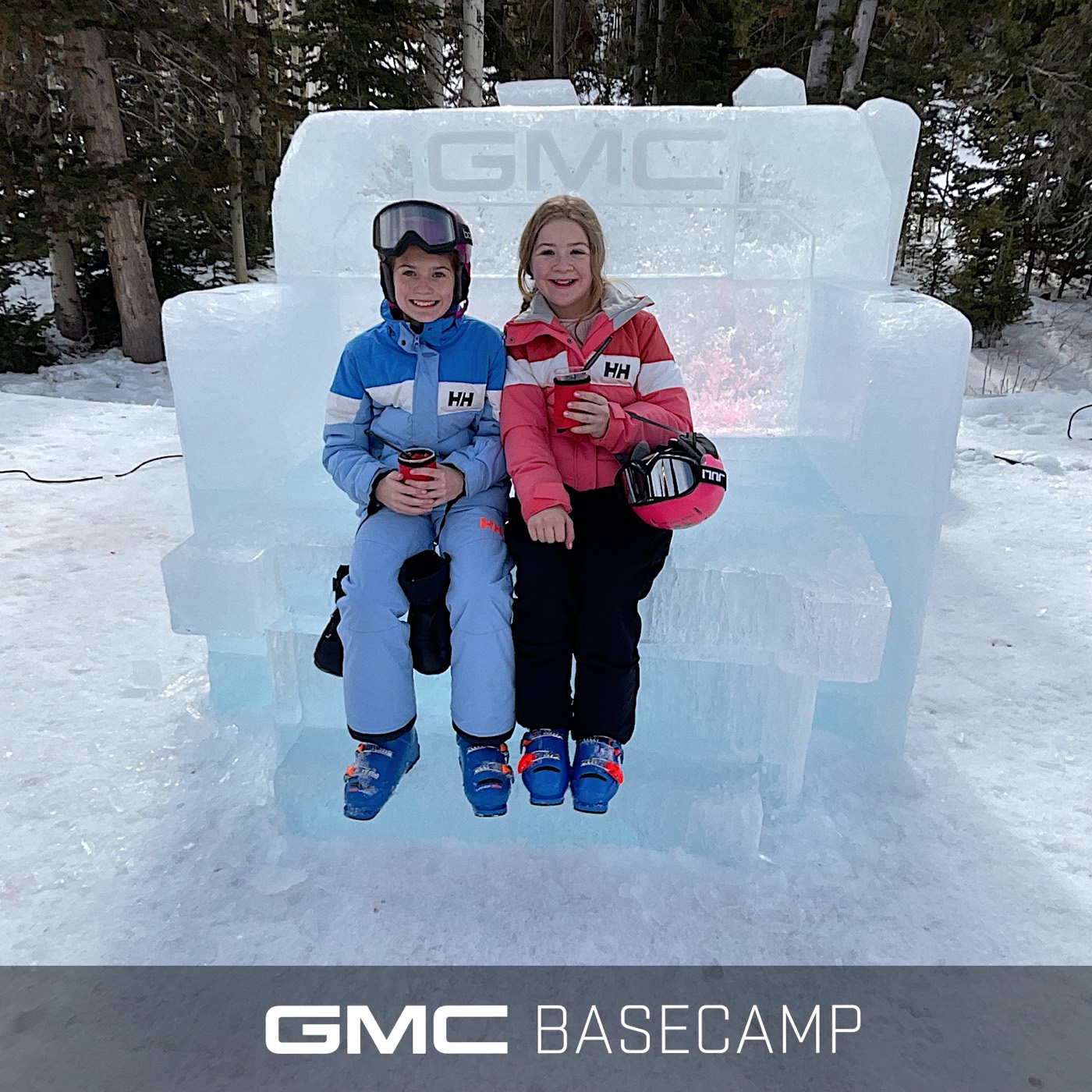 Kids on a carved-ice GMC truck at a GMC Basecamp winter activation